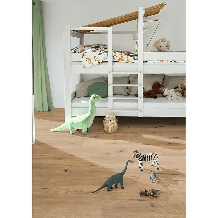 Egger Laminat Aquadura+ - Wildeiche natur, Landhausdiele, 1.292 x 193 x 7,5 mm - Ein helles Kinderzimmer mit einem weißen Etagenbett, das mit Dinosaurierbettwäsche und Spielzeug wie Plüsch- und Plastikdinosauriern dekoriert ist.