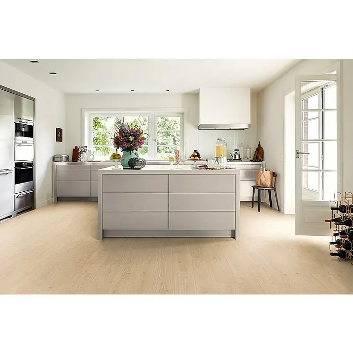 Egger Laminat Aquadura+ - Berdal Eiche hellbraun, Landhausdiele, 1.292 x 193 x 7,5 mm - Helle Küche mit einer Kücheninsel mit Schubladen, weißen Wänden und hellem Holzboden, die ein modernes und stilvolles Ambiente schafft.