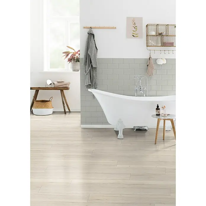 Egger Laminat Aquadura+ - Halifax Eiche creme, Landhausdiele, 1.292 x 246 x 7,5 mm - Ein helles Badezimmer mit weißen Holzböden, einer freistehenden Badewanne und dekorativen Akzenten für ein entspannendes Ambiente.