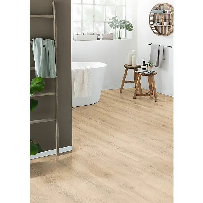 Egger Laminat Aquadura+ - Savona Eiche sand, Landhausdiele, 1.292 x 246 x 7,5 mm - Badezimmer mit freistehender Badewanne, Holzfußboden und dekorativen Elementen wie einer Leiter und Holzhockern für ein entspannendes Ambiente.