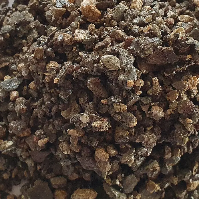 Hamann Mercatus Bau-& Streusplitt - Braun, Körnung: 2 mm - 4 mm, 25 kg - Nahaufnahme von dunklem, unregelmäßigem Granulat, z.B. Mineralsubstrat oder Kies, mit erdigen Tönen und leichtem Glanz.