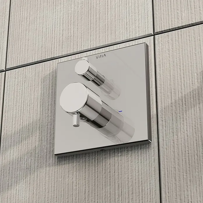 VitrA Flow Square UP-Badewannenarmatur - Ausladung Armatur: 91 mm, Chrom, Glänzend - Wandmontierter Duschmischer mit quadratischer Chromplatte und zwei polierten zylindrischen Bedienelementen an einer strukturierten Fliesenwand.