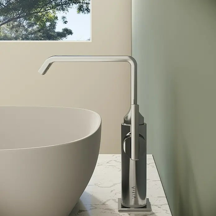 VitrA Suit Waschtischarmatur - Chrom, Glänzend, Ohne Zugstange, Höhe: 25,7 cm - Moderner VitrA Standarmatur aus gebürstetem Stahl, neben einem weißen Waschbecken auf Marmor, in einem modernen Bad.