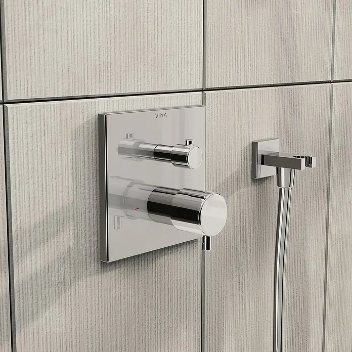 VitrA Flow Square UP-Badewannenarmatur - Ausladung Armatur: 91 mm, Chrom, Glänzend - Verchromte Duscharmatur mit zwei Griffen und separatem Anschluss für eine Handbrause, an einer strukturierten Fliesenwand montiert.
