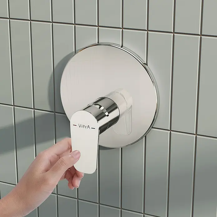 VitrA Flow Soft Brausearmatur - Chrom, Glänzend, Ausladung Armatur: 88 mm, Ohne Hülse - Eine Hand verstellt eine verchromte VitrA Duscharmatur mit weißem Griff an einer gefliesten Wand.