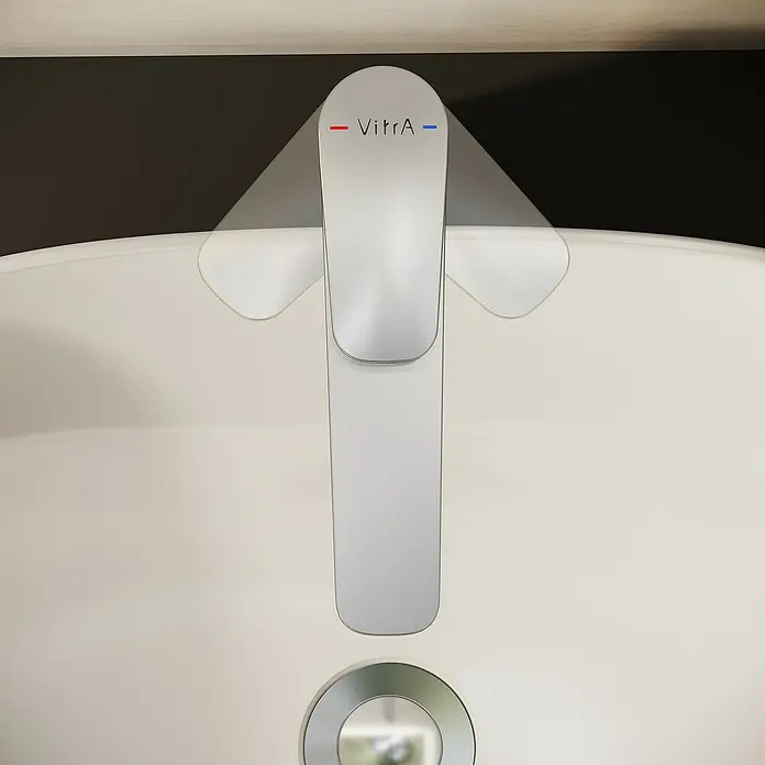 VitrA Flow Soft Waschtischarmatur - Höhe: 29,3 cm, Mit Zugstange, Chrom - Metallischer VitrA-Wasserhahn mit Heiß-/Kaltanzeigen in einem weißen Waschbecken.