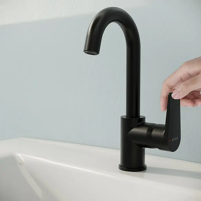 VitrA Flow Square Waschtischarmatur - Schwarz, Matt, Höhe: 28 cm - Schwarze, matte Armatur mit gebogenem Auslauf und Hebel, von einer Hand in einem weißen Waschbecken bedient.