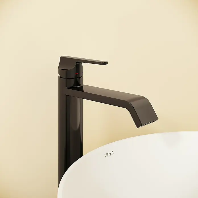 VitrA Suit Waschtischarmatur - Schwarz, Glänzend, Höhe: 26,4 cm - Mattschwarzer Wasserhahn und weißes VitrA Keramikwaschbecken vor einer hellbeigen Wand.