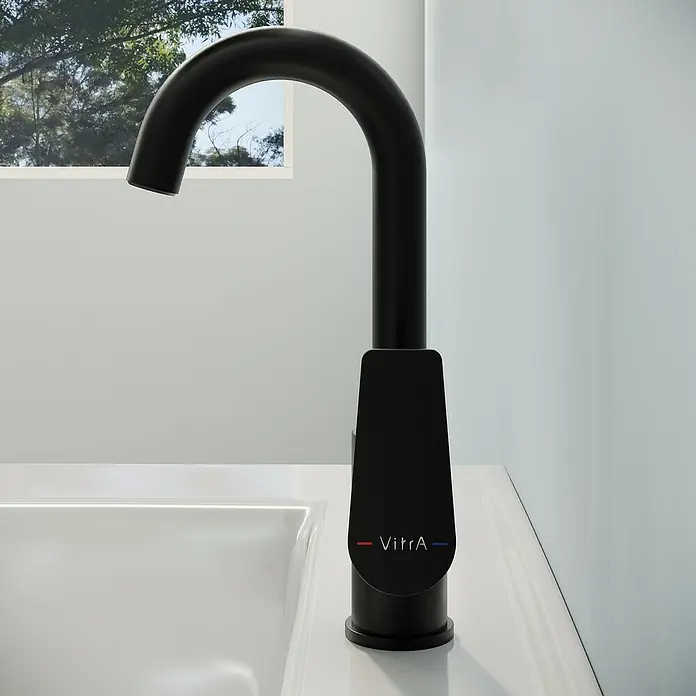 VitrA Flow Square Waschtischarmatur - Schwarz, Matt, Höhe: 28 cm - Ein matter schwarzer VitrA Wasserhahn mit hohem, gebogenem Auslauf über einem weißen Waschbecken. VitrA-Logo mit roten und blauen Linien.