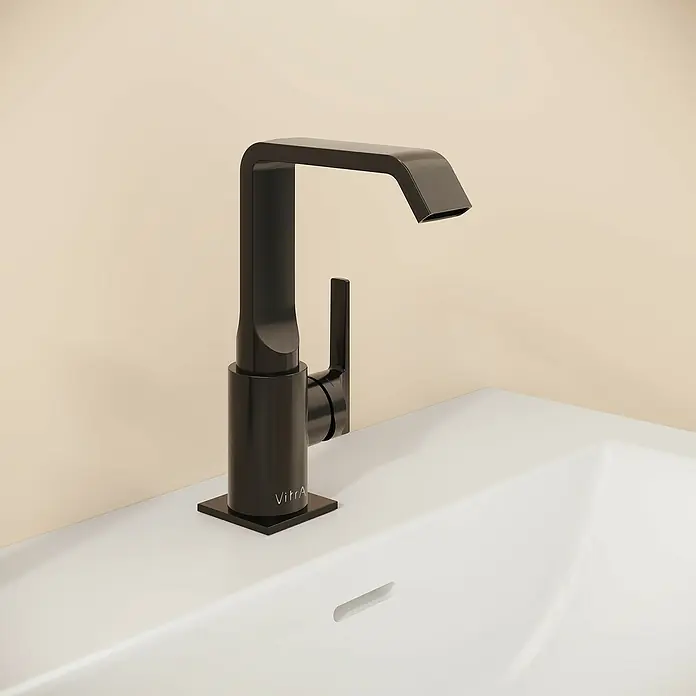 VitrA Suit Waschtischarmatur - Schwarz, Glänzend, Mit Zugstange, Höhe: 20,6 cm - Mattschwarze Armatur mit rechteckigem Auslauf und Hebelgriff, auf einem weißen Waschbecken vor einer hellbeigen Wand installiert.