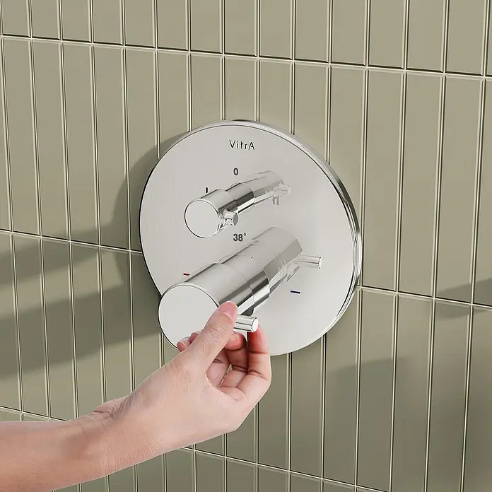 VitrA Flow Soft UP-Badewannenarmatur - Chrom, Glänzend, Ausladung Armatur: 88 mm, Inclusive Hülse - Verchromte VitrA Duscharmatur mit zwei Griffen, einer von Hand an einer gefliesten Wand eingestellt, zeigt 38°.