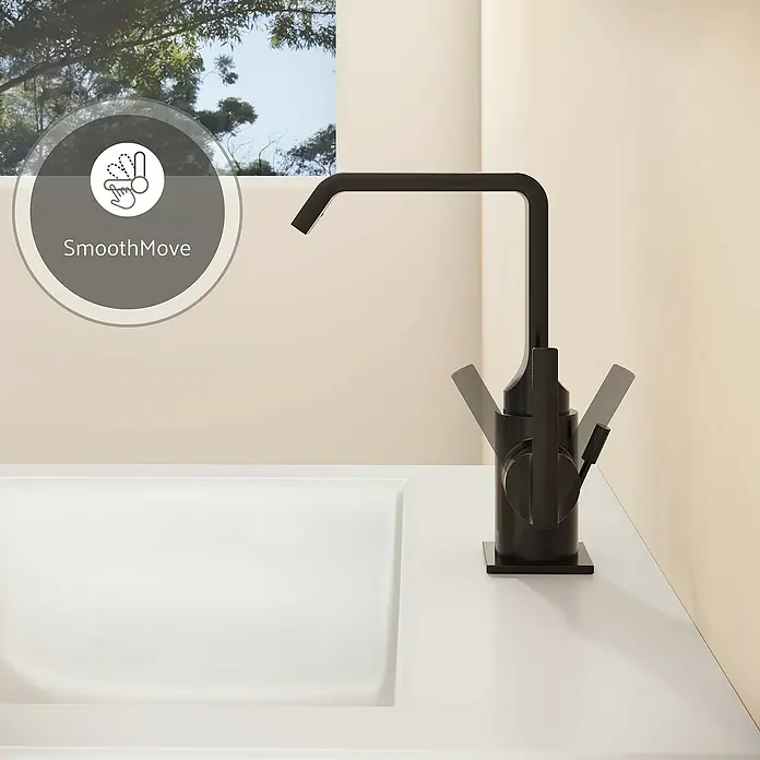 VitrA Suit Waschtischarmatur - Schwarz, Glänzend, Mit Zugstange, Höhe: 20,6 cm - Moderner schwarzer Küchenarmatur mit bewegtem Griff über einem weißen Waschbecken, inklusive 'SmoothMove' Symbol. Vor einem Fenster.