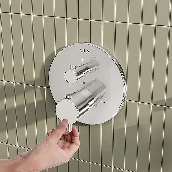 VitrA Flow Soft UP-Badewannenarmatur - Chrom, Glänzend, Ausladung Armatur: 88 mm, Inclusive Hülse - Polierter Chrom-Duschmischer an einer gefliesten Wand, eine Hand betätigt einen Regler.