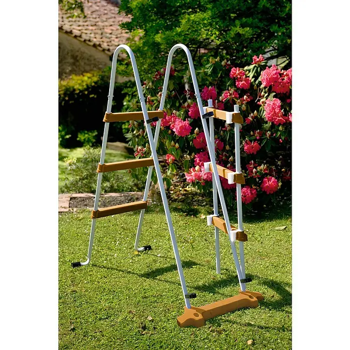 Gre Piscina de acero desmontable Pacific - L x An x Al: 500 x 300 x 120 cm, Marrón claro, 14.550 l - Una escalera de piscina de dos peldaños blanca y marrón, colocada frente a un césped verde y flores rosas.