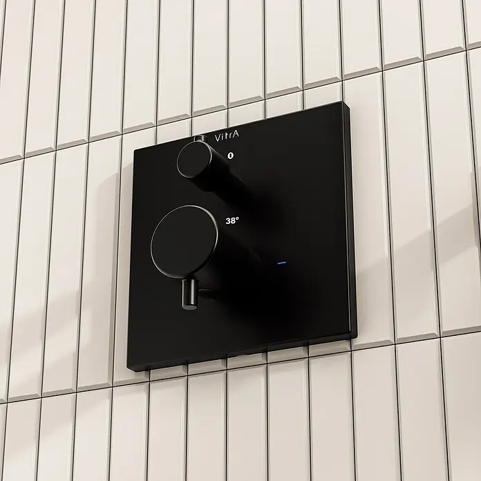 VitrA Flow Square UP-Badewannenarmatur - Ausladung Armatur: 89 mm, Schwarz, Matt - Mattschwarzer quadratischer Duschmischer mit zwei Drehreglern und blauer Anzeigeleuchte auf hellen vertikalen Fliesen montiert.
