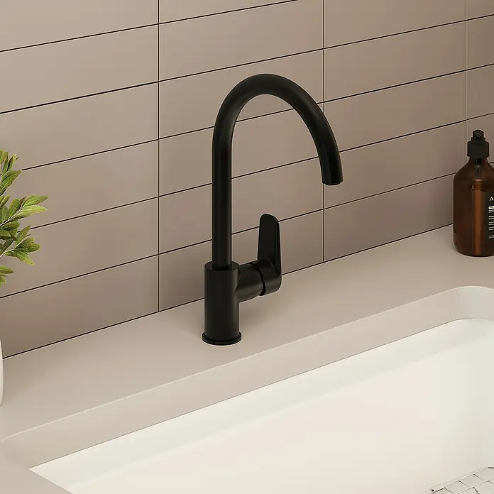 VitrA Flow Soft Spültischarmatur - Fester Auslauf, Schwarz, Matt, Höhe: 35,2 cm - Mattschwarze Küchenarmatur mit gebogenem Auslauf und Einhebelgriff auf einer hellbeigen Arbeitsplatte über einem weißen Waschbecken mit beiger Fliesenrückwand.