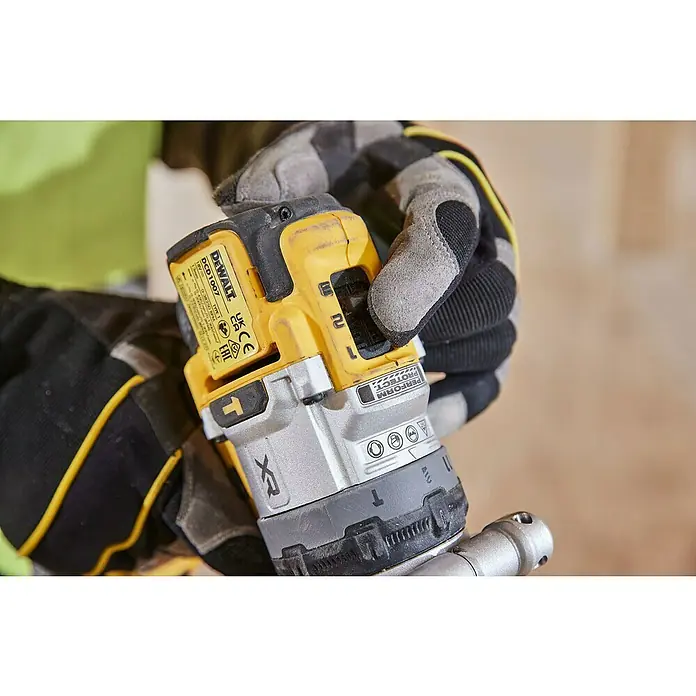 DeWalt XR 18V Taladro atornillador percutor de batería DCD1007W -  - Un primer plano de un taladro inalámbrico DeWalt sostenido por una persona que usa guantes de trabajo.