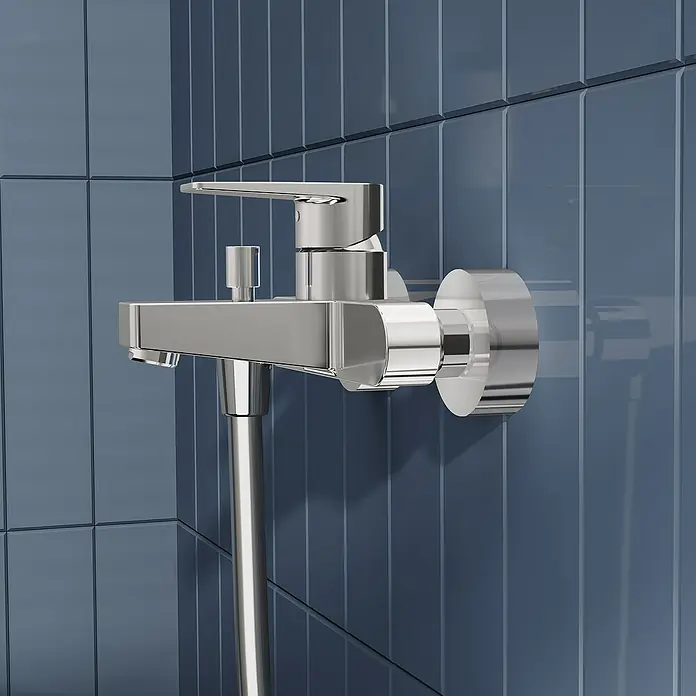 VitrA Flow Square Badewannenarmatur - Chrom, Glänzend - Chrom Duscharmatur mit Schlauch, an einer blauen gefliesten Wand montiert.