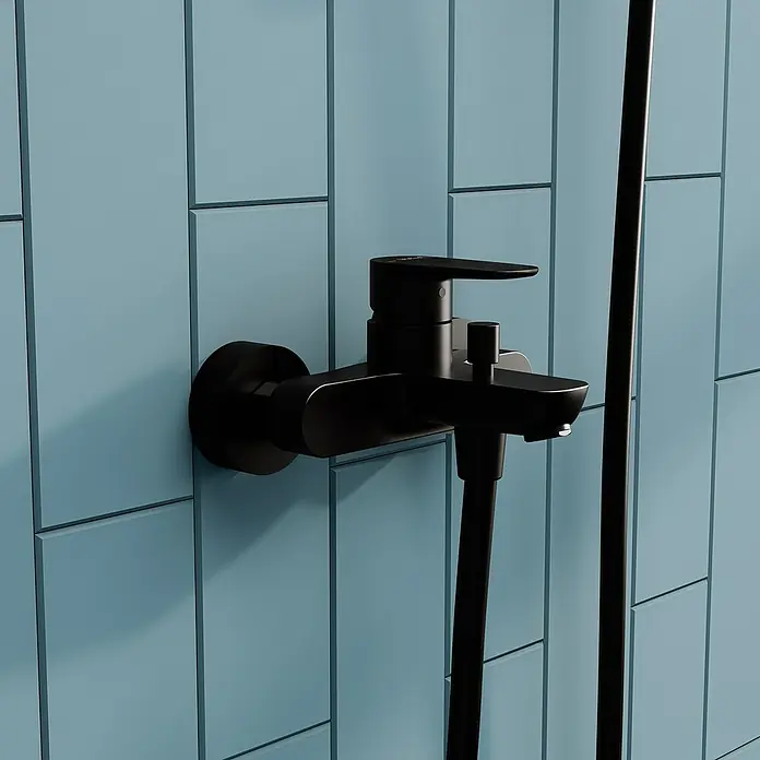 VitrA Flow Soft Badewannenarmatur - Schwarz, Matt - Mattschwarzer Duschmischer mit Brauseschlauch an hellblauer Fliesenwand.