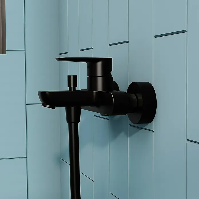 VitrA Flow Soft Badewannenarmatur - Schwarz, Matt - Mattschwarze Duscharmatur mit integriertem Auslauf und Schlauchanschluss, an blauer Fliesenwand montiert.