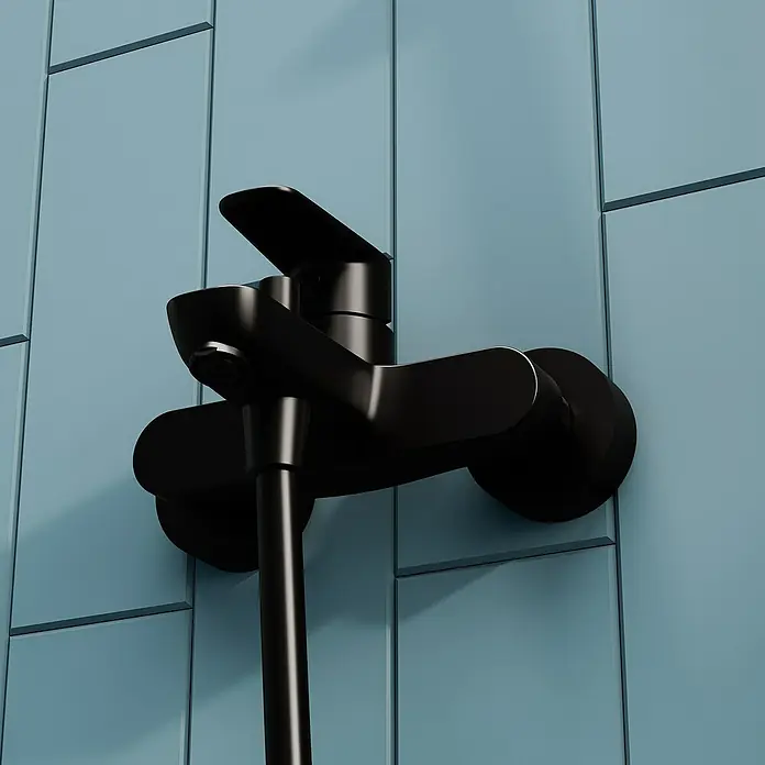 VitrA Flow Soft Badewannenarmatur - Schwarz, Matt - Mattschwarze Duscharmatur an einer blauen Fliesenwand montiert.