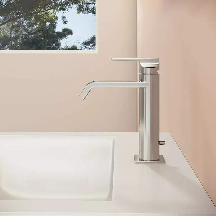 VitrA Suit Waschtischarmatur - Chrom, Glänzend, Höhe: 19 cm - Moderner Einhebelmischer aus gebürstetem Chrom auf einer weißen Waschtischplatte, in einem warmen, natürlich beleuchteten Badezimmer.