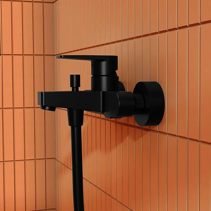 VitrA Flow Square Badewannenarmatur - Schwarz, Matt - Schwarze Duscharmatur mit Schlauch, an einer orangefarbenen Fliesenwand montiert.