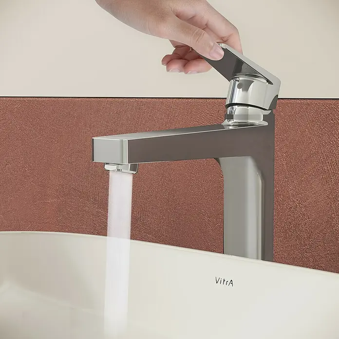 VitrA Flow Square Waschtischarmatur - Chrom, Glänzend, Höhe: 30 cm, Mit Zugstange - Chromarmatur mit Wasserlauf in ein weißes Waschbecken, von einer Hand bedient.