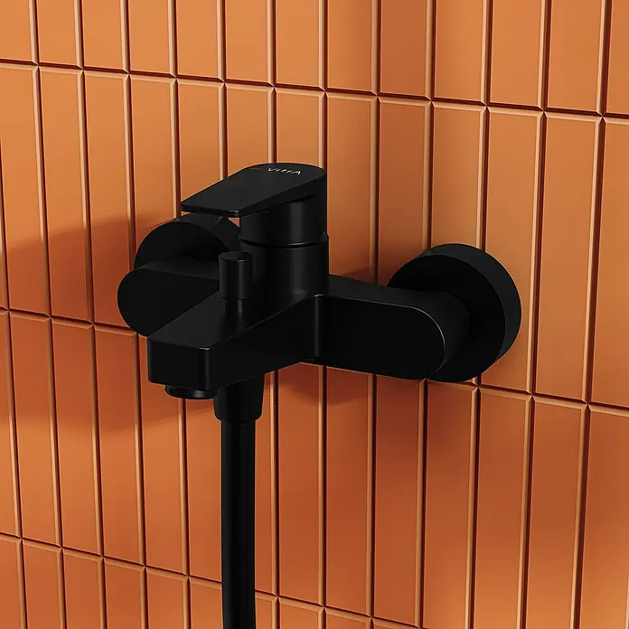 VitrA Flow Square Badewannenarmatur - Schwarz, Matt - Mattschwarze Duscharmatur mit Schlauchanschluss an oranger Wandfliese.
