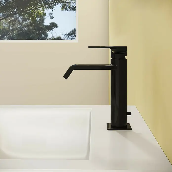 VitrA Suit Waschtischarmatur - Schwarz, Glänzend, Höhe: 19 cm - Hoher, mattschwarzer Badarmatur mit schlankem Design auf einer weißen Arbeitsplatte und Waschbecken in einem hellen Badezimmer.