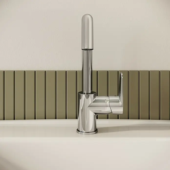 VitrA Flow Soft Waschtischarmatur - Chrom, Glänzend, Höhe: 28 cm - Moderner Chrom-Wasserhahn mit hohem Auslauf und Einhebelgriff über weißem Waschbecken vor olivgrünen Riffelkacheln.