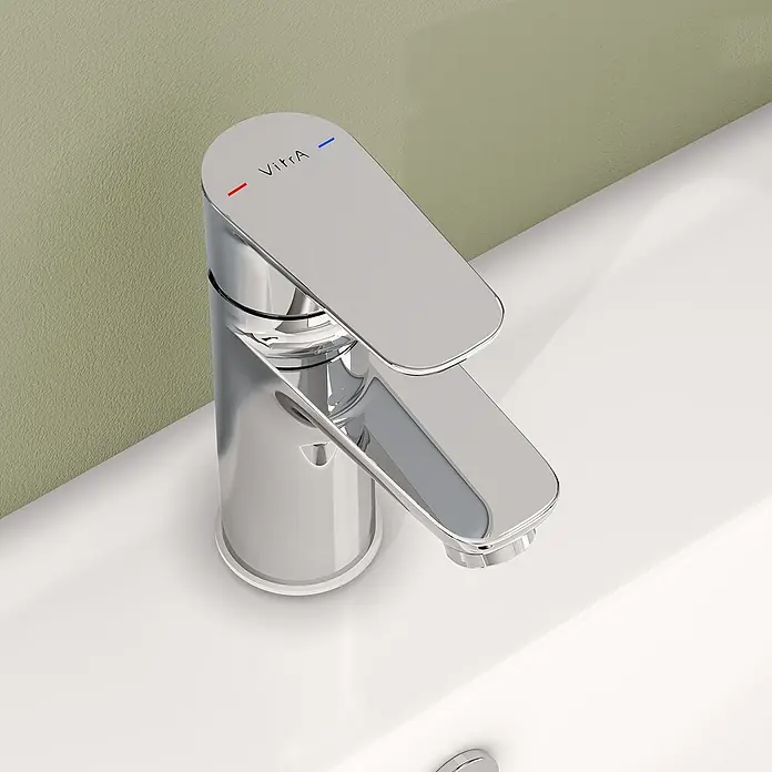 VitrA Flow Soft Waschtischarmatur - Chrom, Höhe: 15 cm, Ohne Zugstange - Verchromte VitrA Einhebel-Waschtischarmatur auf einem weißen Waschbecken mit roten und blauen Heiß/Kalt-Markierungen.