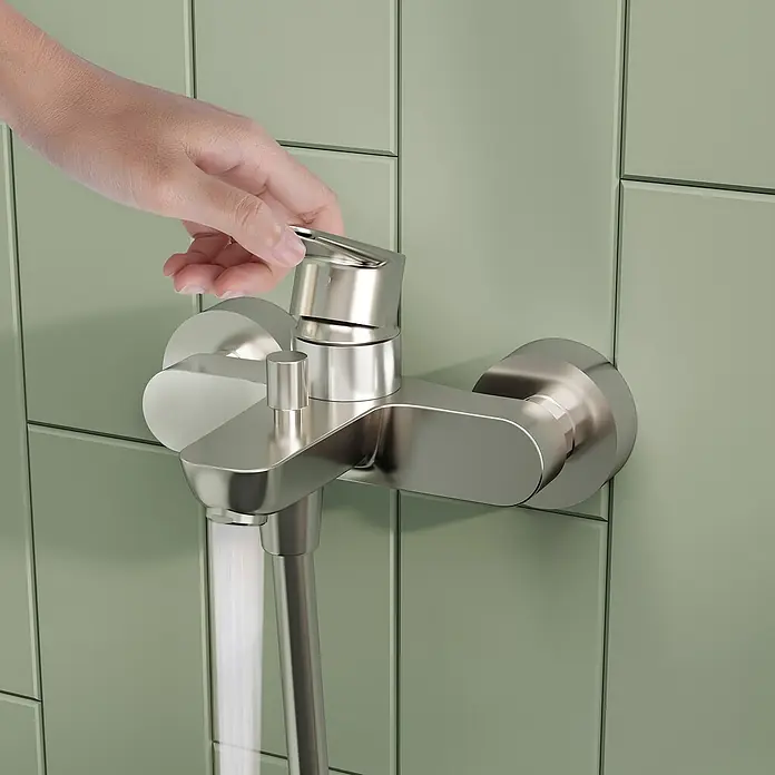 VitrA Flow Soft Badewannenarmatur - Chrom, Glänzend - Hand betätigt einen Duschmischer aus gebürstetem Nickel, Wasser fließt.