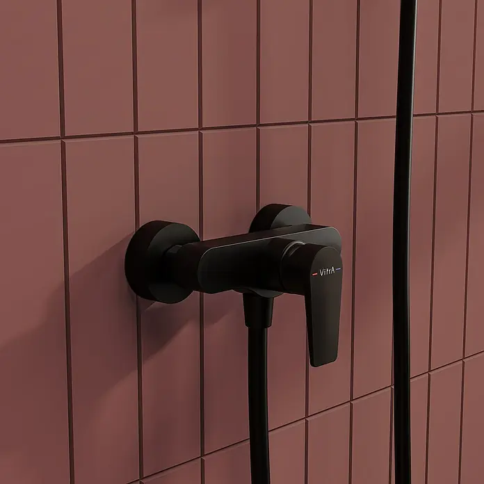 VitrA Flow Square Brausearmatur - Ausladung: 12,7 cm, Schwarz, Matt - Mattschwarzer Duschmischer an einer rotbraunen Fliesenwand.