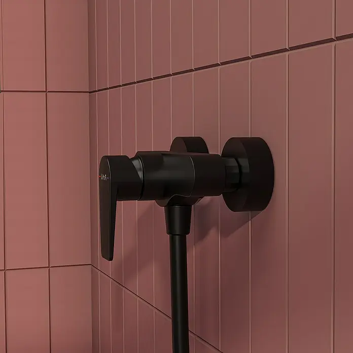 VitrA Flow Square Brausearmatur - Ausladung: 12,7 cm, Schwarz, Matt - Mattschwarze Duscharmatur mit Schlauch an einer rotbraunen Fliesenwand.