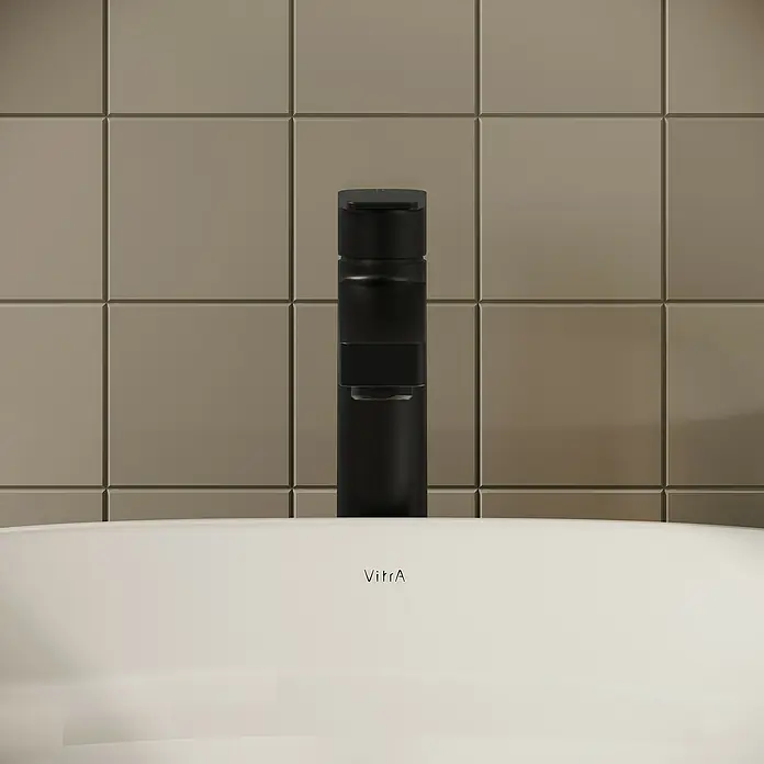 VitrA Flow Square Waschtischarmatur - Schwarz, Matt, Höhe: 30 cm, Mit Zugstange - Schwarze Armatur über einem weißen VitrA Waschbecken vor einer gefliesten Badwand.