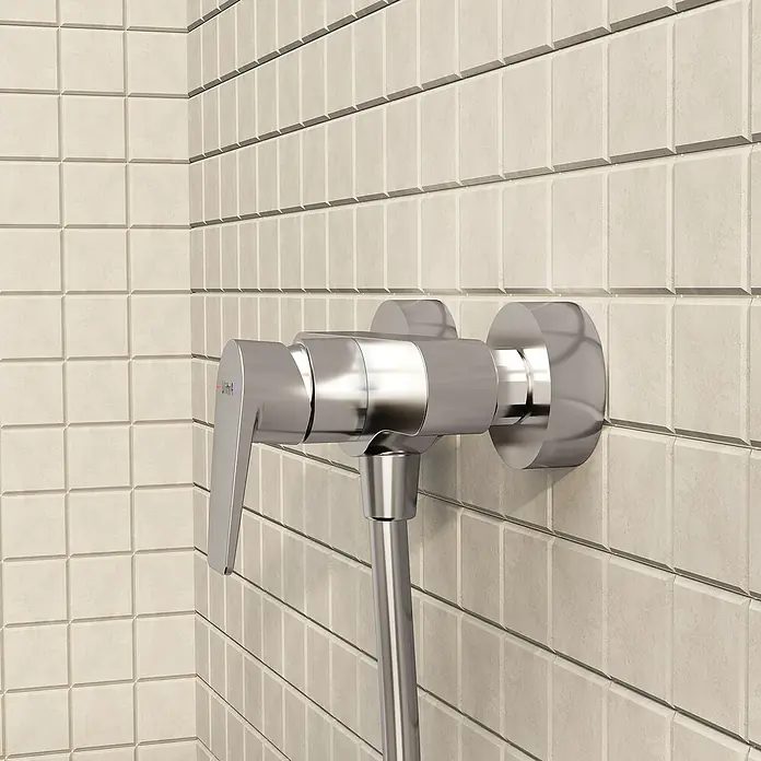 VitrA Flow Square Brausearmatur - Ausladung: 12,7 cm, Chom, Glänzend - Verchromte Duscharmatur mit angeschlossenem Schlauch an einer gefliesten Wand.