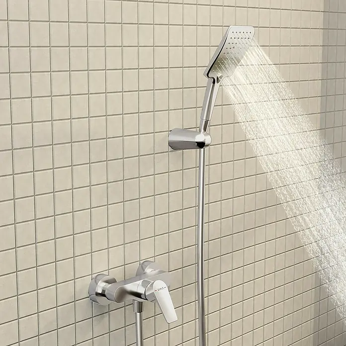 VitrA Flow Square Brausearmatur - Ausladung: 12,7 cm, Chom, Glänzend - Chrom-Duschset sprüht Wasser auf einer gefliesten Wand.