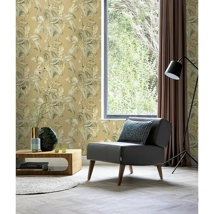 Rasch Back To Nature Vliestapete Blätter - Beige-Greige, Floral, 10,05 x 0,53 m - Moderner grauer Sessel mit blauem Kissen in einem stilvollen Wohnzimmer mit floraler Tapete.