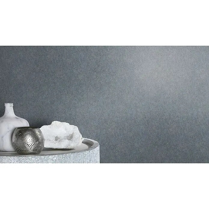 Rasch Selection Vliestapete - Dunkelblau, Uni, 10,05 x 0,53 m - Nahaufnahme eines Tisches mit einer Marmorvase, einem silbernen Kerzenhalter und einem weißen Kristall, der eine elegante Atmosphäre schafft.