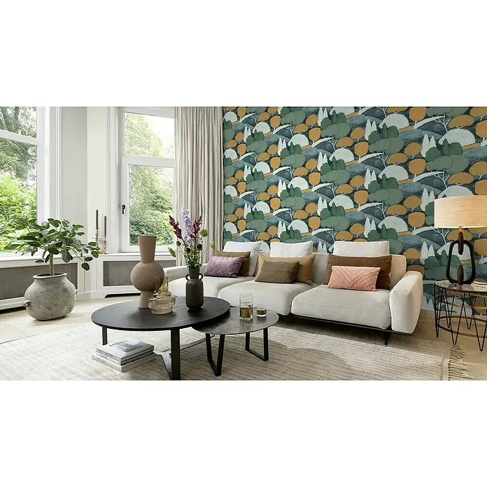 Rasch Selection Vliestapete Vinyl Botanical - Moosgrün/Ocker, Floral, 10,05 x 0,53 m - Ein Wohnzimmer mit einer modernen Couch, einem Couchtisch und einer stilvollen Stehlampe. Die Tapete mit Baumdesign setzt einen auffälligen Akzent.