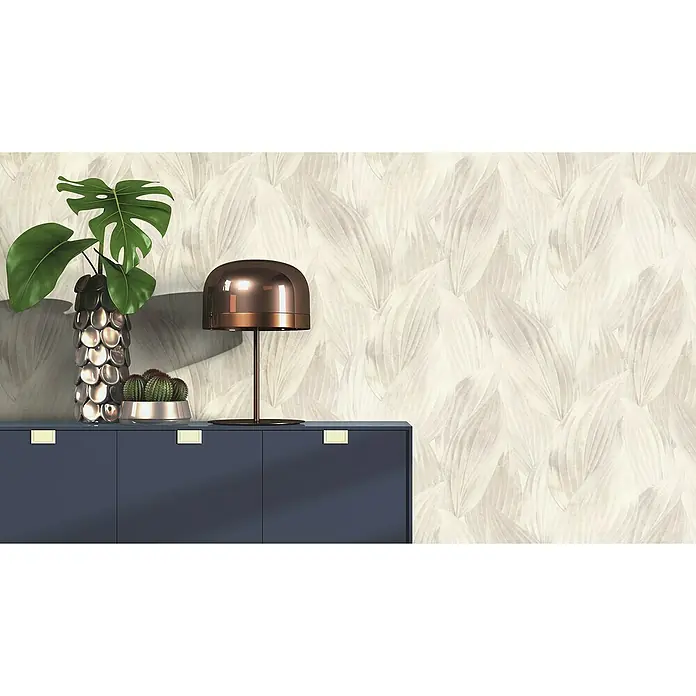 Rasch Back To Nature Vliestapete Blätterintarsie - Grau, Floral, 10,05 x 0,53 m - Nahaufnahme eines modernen Sideboards in Marineblau mit Zimmerpflanzen und einer Lampe, vor einer Wand mit Blattmuster.
