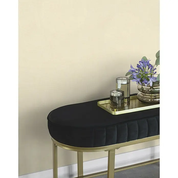 Rasch Beachhouse Vliestapete - Beige, Uni, 10,05 x 0,53 m - Elegante schwarze Samtbank mit goldenem Gestell, dekoriert mit Gläsern, einem goldenen Tablett und einer Blumenarrangements.