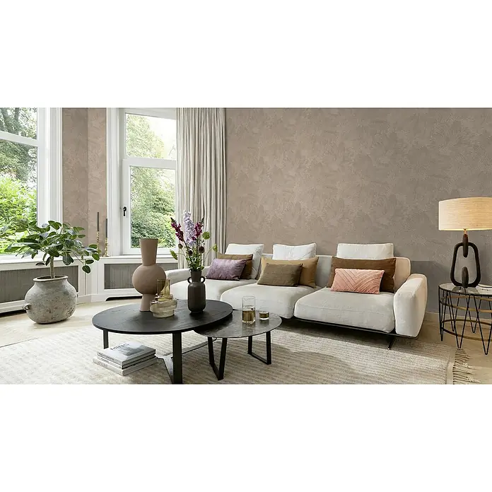 Rasch Selection Vliestapete Vinyl Hintergrundblume - Rosabraun, Floral, 10,05 x 0,53 m - Wohnzimmer-Interieur mit einem hellen Sofa, Kaffeetischen, Zimmerpflanzen und einer Stehlampe, die eine gemütliche Atmosphäre schaffen.