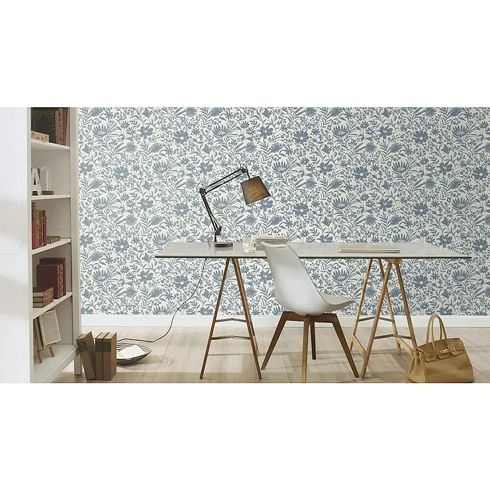 Rasch Paraiso Vliestapete Blumen - Weiß/Blau, Floral, 10,05 x 0,53 m - Ein Schreibtisch mit floraler Tapete, einer Lampe, einem Stuhl und einer hellbraunen Handtasche auf dem Boden.