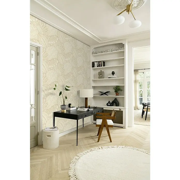 Rasch Selection Vliestapete Vinyl Modern Art II - Hellgold, Floral, 10,05 x 0,53 m - Stilvolles Interieur mit floral gemusterter Tapete, schwarzem Schreibtisch, Holzstuhl, Bücherregal und einem runden Teppich für ein gemütliches Ambiente.