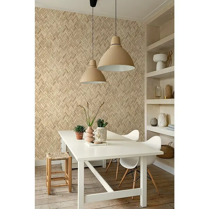 Rasch Beachhouse Vliestapete Vintage Fischgrätmuster - Hellbraun, Holzoptik, 10,05 x 0,53 m - Esszimmer mit großem, weißem Tisch, Stühlen und zwei Pendelleuchten. Die Wand ist mit einem auffälligen Ziegelmuster versehen.