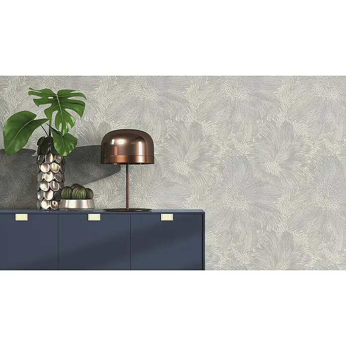 Rasch Selection Vliestapete Vinyl Hintergrundblume - Grau, Floral, 10,05 x 0,53 m - Nahaufnahme eines eleganten Sideboards mit Dekoartikeln wie einer Pflanze, einem Kaktus und einer Lampe, vor einer floral gemusterten Wand.