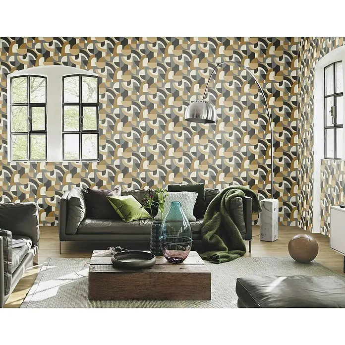 Rasch Selection Vliestapete Vinyl - Mehrfarbig/Schwarz, Grafisch, 10,05 x 0,53 m - Ein Wohnzimmer mit einem Ledersofa, Couchtisch und einem auffälligen geometrischen Tapetenmuster, das dem Raum einen modernen Touch verleiht.