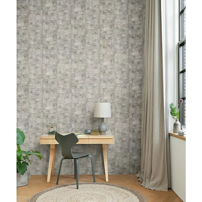 Rasch Selection Vliestapete Mauerwerk - Steingrau, Steinoptik, 10,05 x 0,53 m - Ein stilvolles Interieur mit einer Wandtapete in Steinoptik, einem hellen Holzschreibtisch und einem modernen Stuhl.